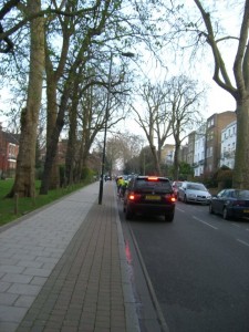 Cyclists in front of cars going uphill on Camberwell Grove
