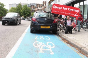 Holding up Space for Cycling banner over a parked car on CS7