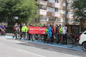 Cyclists holding up Space for Cycling banner